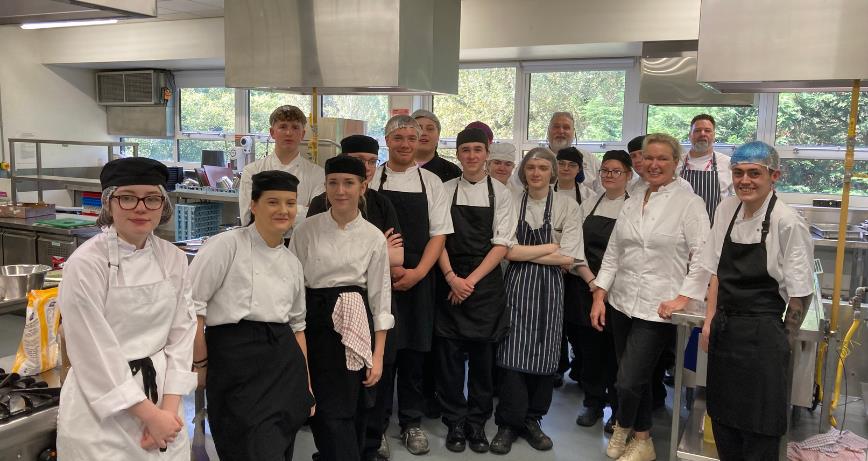 Preparing for the Demo and Dine with Rachel Allen were Level  FDQ Traineeship Professional Chef students (L – R) Ellen Beckett (Lisburn) Rhiann Robinson (Bangor) , Frank Humphreys(Ards) Brooke Nutt, Alex Hull, Owen Mendez,  Leyton Robinson (Bangor) Callum Nicholl (all Bangor) Alyx Loughlin (Ards), Reuben Morrow, Lecturer Brian Magill, Trinity Morrison, Michaela Henders, and Jamie Blair (all Lisburn) with cookery writer and  tv celebrity Rachel Allen, Lecturer Friedrich Machala, and Jack Regan from the Level 3 Professional Chef (Bangor).