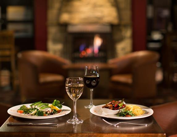 Table set for two with meals and glasses of wine