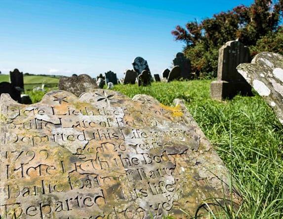 Close up photo of one of the gravestones, with others within view