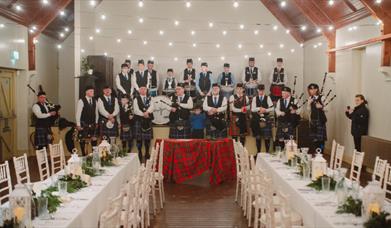 Image of the Harry Ferguson Memorial Pipe Band in the Parochial Hall at the Ulster Folk Museum