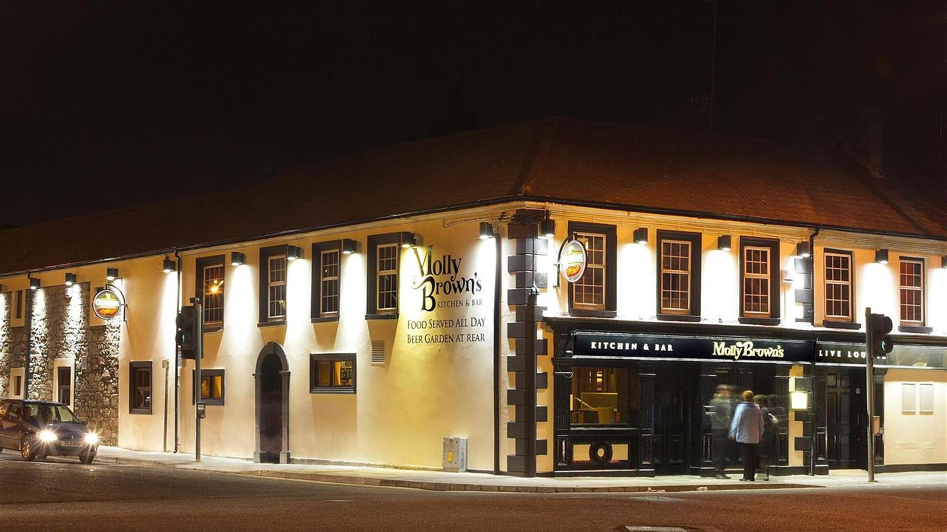 Front exterior of restaurant lit up at night