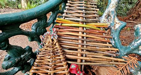 WILLOW CHRISTMAS TREES SITTING ON A GARDEN BENCH