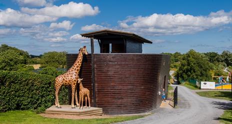 Image of the Ark Open Farm's small replica of Noah's Ark with animal statues including giraffe