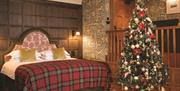 A double bedroom with a Christmas tree beside the bed