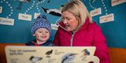 Mother and son learning bird ID in the Brent Discovery Hide