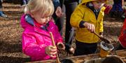 Two children playing at a mud kitchen.