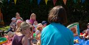 Young families sitting on picnic blankets listening to stories with a WWT staff member.