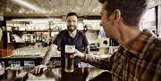 Male getting drink at the bar from the barman