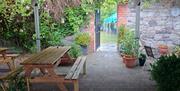 Exterior of No. 14 Georgian House Comber, looking from Courtyard into the Walled Garden, with picnic benches and shrubbery in view