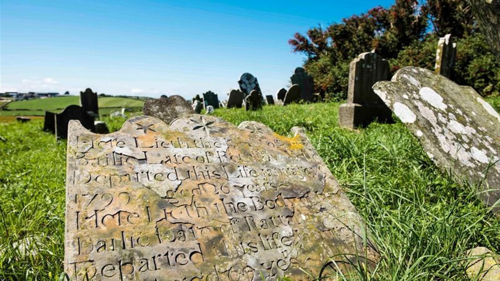 Close up photo of one of the gravestones, with others within view